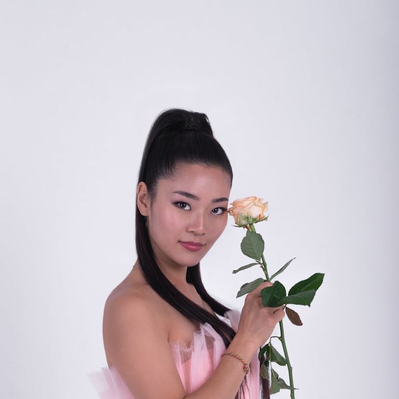 A person in a dynamic but graceful pose in a bright, open space.