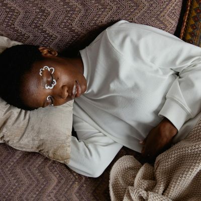 Person sitting peacefully with eyes closed in a moment of calm.