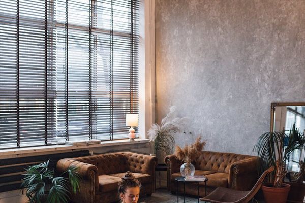 Person stretching calmly in a minimalist room with natural light.
